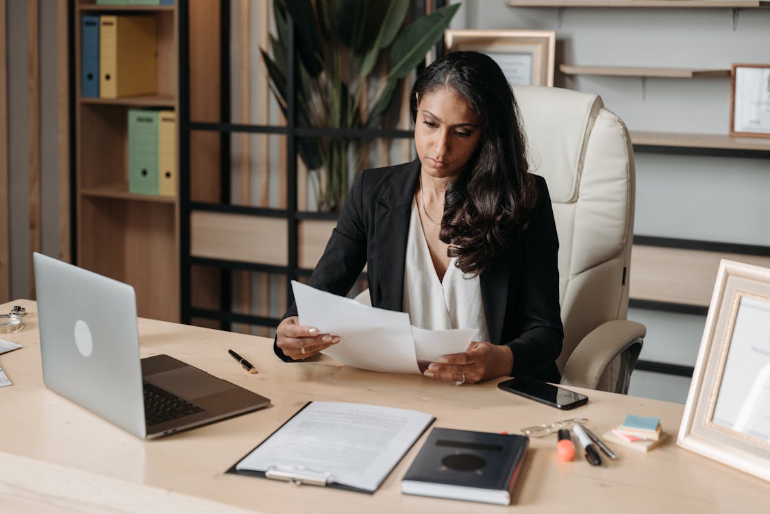 Professional auditor reviewing documents at office desk